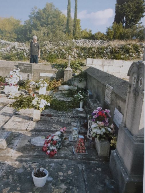 Grob u koji je pokopan živ Krsto Tanfara Pelin. Nikola Franić stoji uz Pelinov grob.